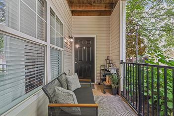 a front porch with a chair and a table on it